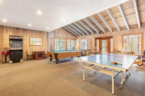 Enjoy games and views in this spacious indoor recreational area with a pool table, ping pong table, and billiards table.