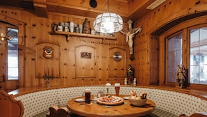 A wooden interior with a round table, benches, and a chandelier. - Gasthof-Metzgerei-Pension Schierlitz (Rimbach)