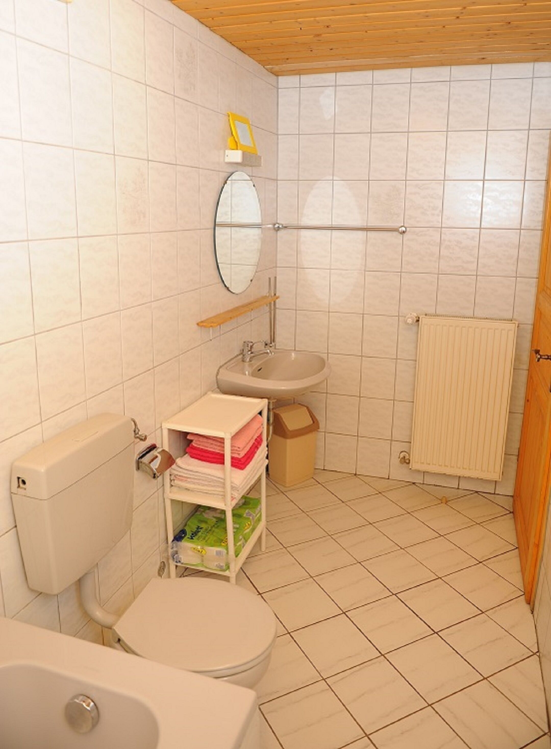 A small bathroom with a toilet, sink, and mirror.