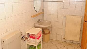 A small bathroom with a toilet, sink, and mirror.