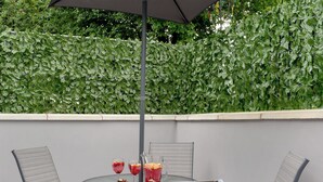 A round table with four chairs, an umbrella, and three drinks. - 2 bedroom accommodation in Topsham, near Exeter (Topsham, near Exeter)