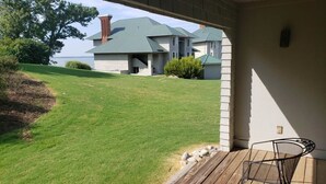 A covered porch with a view of a house and a body of water. - Water-view in Kingsmill, 10 minutes to Busch Gardens & Colonial Williamsburg! (Williamsburg)