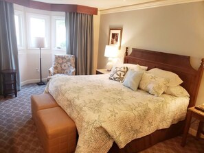 A hotel room with a large bed, a chair, a bedside table, and a floor lamp. - Water-view in Kingsmill, 10 minutes to Busch Gardens & Colonial Williamsburg! (Williamsburg)