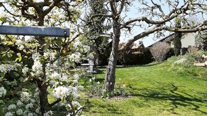 A garden with flowering trees and a lawn. - Ferienwohnung Lucretia a3 (Ruhstorf)