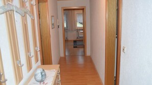 A narrow hallway with wooden flooring and a wooden door at the end. - Ferienwohnung Stoiber (Frauenau)