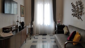 A living room with a sofa, a coffee table, a TV, and a decorative wall piece.