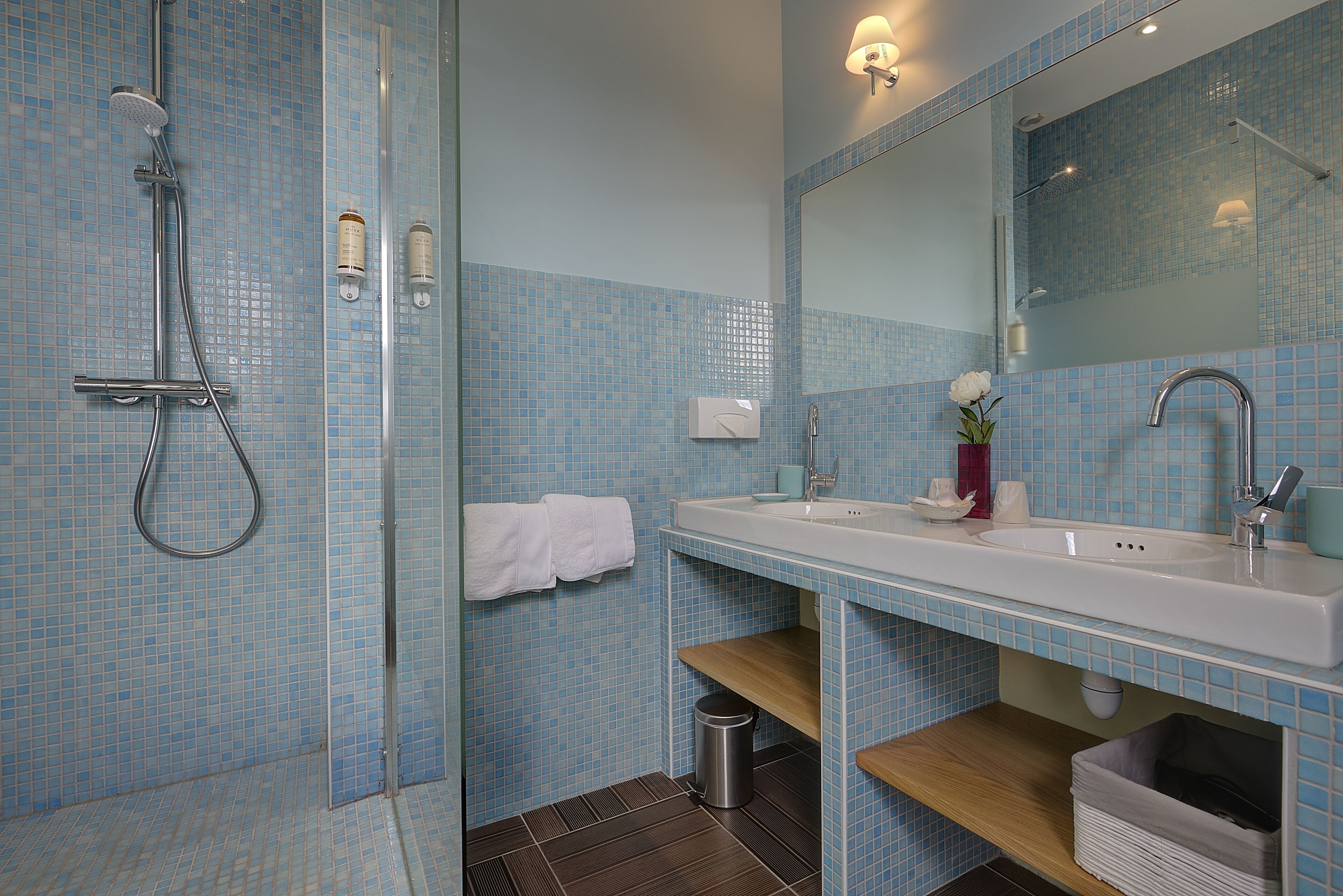 A bathroom with a shower, sink, and mirror.