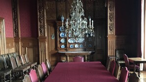A formal dining room with a large table, ornate chairs, and a chandelier. - Château de Joyeux - Chambres D'hôtes (Joyeux)