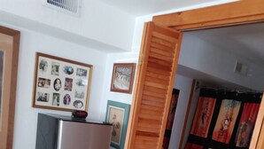 A compact kitchen with a refrigerator, wooden cabinets, and a red rug. - Beautiful Ocean Front Studio with direct beach and access to a deck.  (Kill Devil Hills)