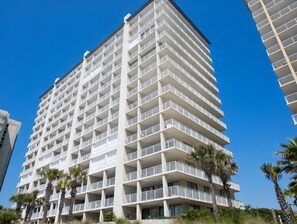 A multi-story hotel with balconies, palm trees, and a clear blue sky. - 14th Floor End Unit w/ Wraparound Balcony (Orange Beach)