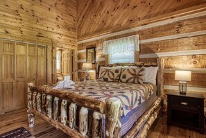 Quarto de cabana de madeira com cama, mesa de cabeceira e guarda-roupa.