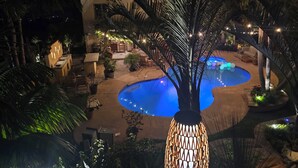 A pool area with a circular pool, surrounded by potted plants and outdoor furniture.