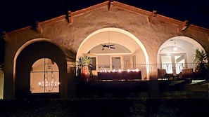 Un edificio con ventanas de arco y un balcón con luces.
