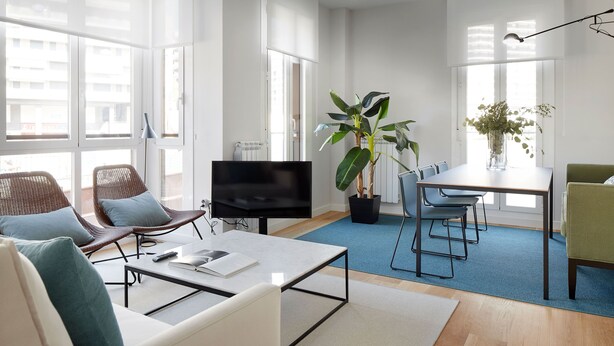 A modern living room with a flat-screen TV, comfortable seating, a dining area, and large windows. - Muinoa 5 by FeelFree Rentals (San Sebastián)