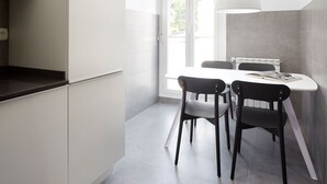 A modern kitchen with white cabinets, a black countertop, and a window providing natural light. - Muinoa 5 by FeelFree Rentals (San Sebastián)