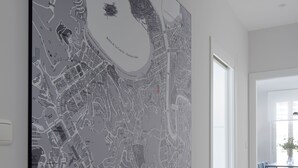 A large map of San Sebastián on a wall, with a modern interior including a wooden floor and a dining area with chairs and a table. - Muinoa 5 by FeelFree Rentals (San Sebastián)