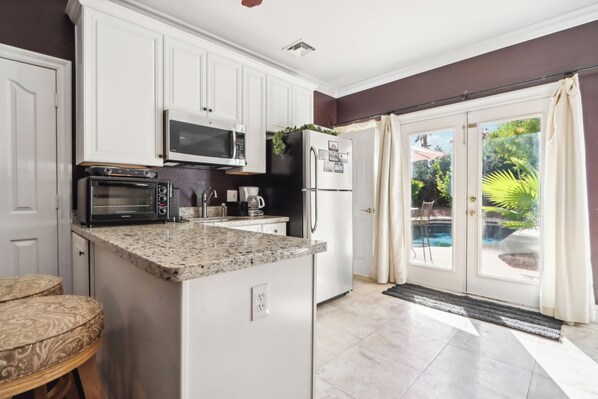 A kitchen with white cabinets, a microwave, a toaster, and a refrigerator. - Classy Guest Suite in Gorgeous Lake Community (Gilbert)