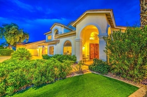 A large, two-story house with a well-maintained lawn and a patio area.