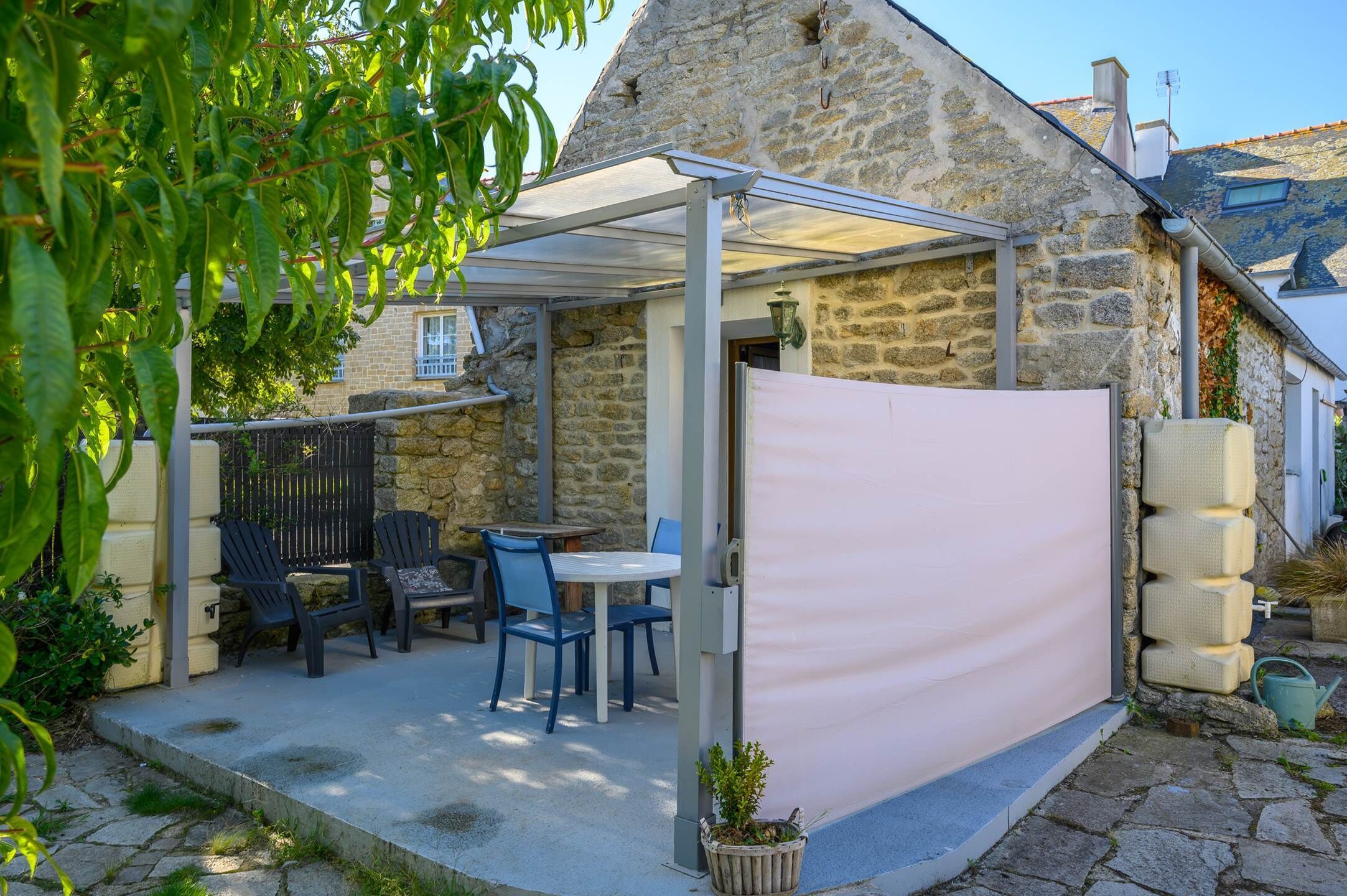 A stone building with a covered patio area featuring outdoor seating and a pergola.