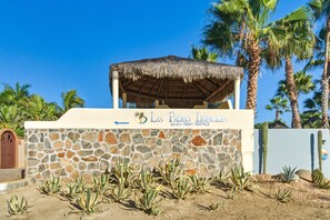 Un mur de pierre avec une enseigne indiquant : « Las Palmas Tropicales, location de logements en bord de mer. »