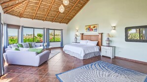 A bedroom with a bed, a sofa, a nightstand, a lamp, a vase, and a painting. - Oceanfront Paradise-New Pool-Steps to San Pedrito Surf Break (Pescadero)