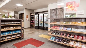 A hotel lobby with a reception desk, vending machines, and shelves stocked with snacks and beverages. - Hotel 10 Balsas (Balsas)