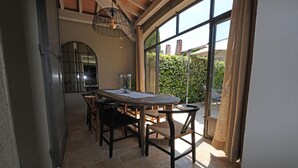 A dining area with a round table, chairs, and a hanging light fixture. - Vacation rental house with pool AUREILLE LS1-277 (Aureille)