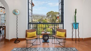 Un balcone con due sedie, un mappamondo e un cactus.
