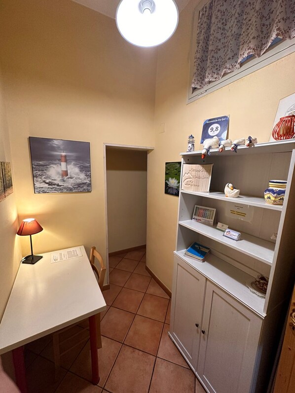 A small, well-lit room with a desk, chair, and a cabinet with shelves. - "Ricomincio Da Qui" a few steps from the historic center (Napoli)