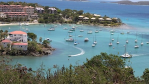 A coastal area with numerous boats anchored in clear turquoise waters, surrounded by lush greenery and buildings with red roofs. - Eureka Villa! Stunning Views in Paradise! 3BR, 3.5BA (Rendezvous Bay)