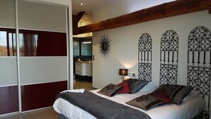 Ein Schlafzimmer mit einem Bett, einem Nachttisch, einer Lampe und Wanddekoration.