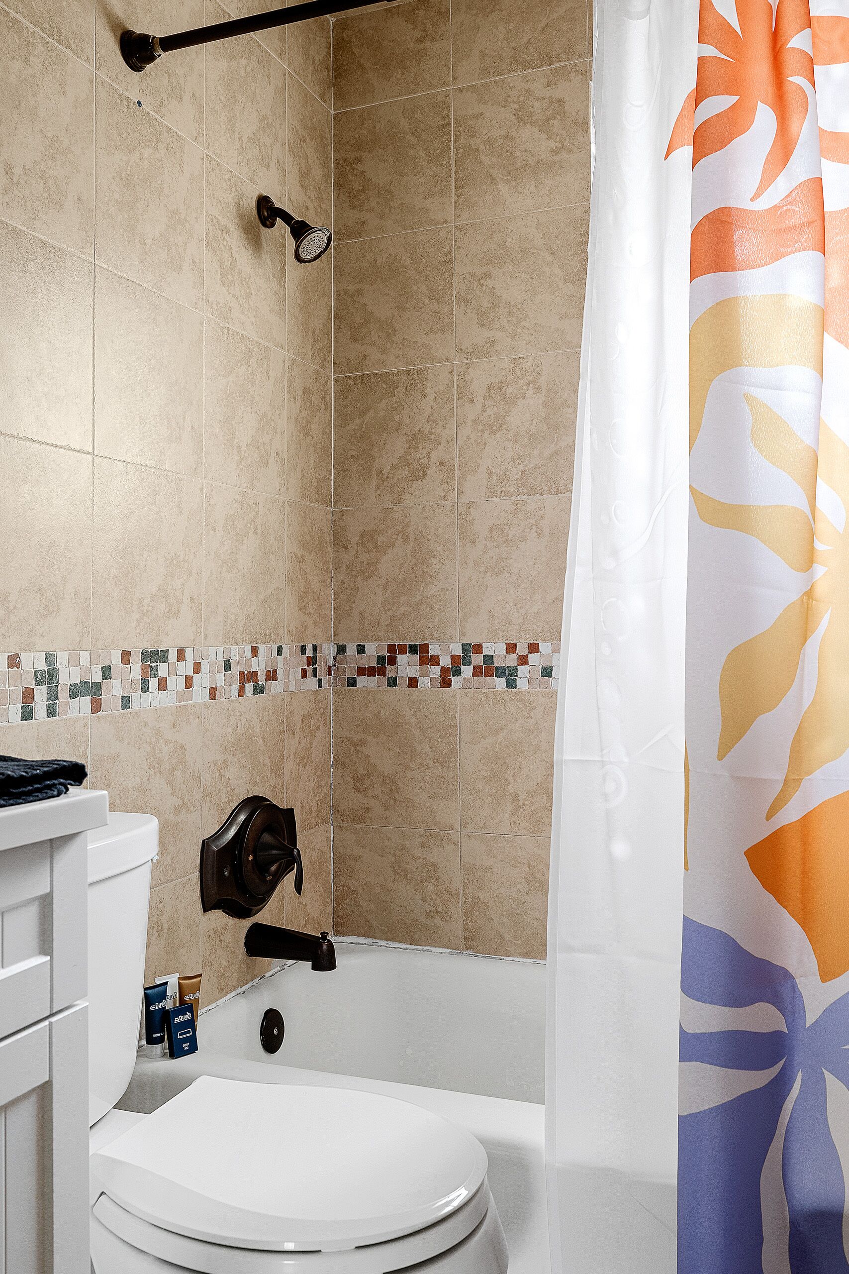 Un baño con bañera, inodoro y cortina de ducha.