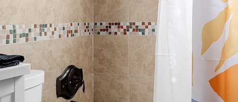 Un baño con bañera, inodoro y cortina de ducha.