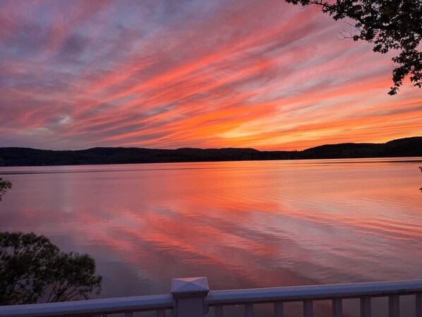 A calm lake at sunset with a clear sky and distant hills. - Hall of Fame Hide Away (Richfield Springs)
