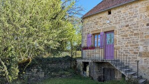 A stone building with a staircase leading to a balcony with purple shutters. - Gite aux Portes du Morvan, 10 minutes from Vézelay (Nuars)