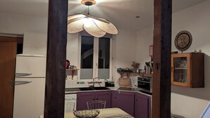 A compact kitchen with a window, a sink, a stove, and purple cabinets. - Bright Duplex in Lille-Wazemmès (Lille)