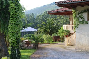 Ein Haus mit Kiesauffahrt, einer Palme und einem weißen Zelt im Hintergrund.
