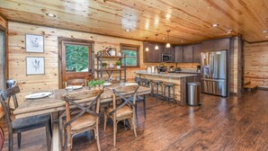 Una cocina amplia con paredes y pisos de madera, una isla central y electrodomésticos modernos.