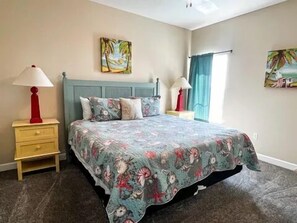 Une chambre à coucher comprenant un lit, deux tables de chevet, une commode, une tête de lit et deux lampes fixées au mur.