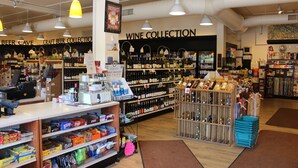 Un magasin avec des étagères remplies de divers produits et un rayon intitulé « COLLECTION DE VINS ».