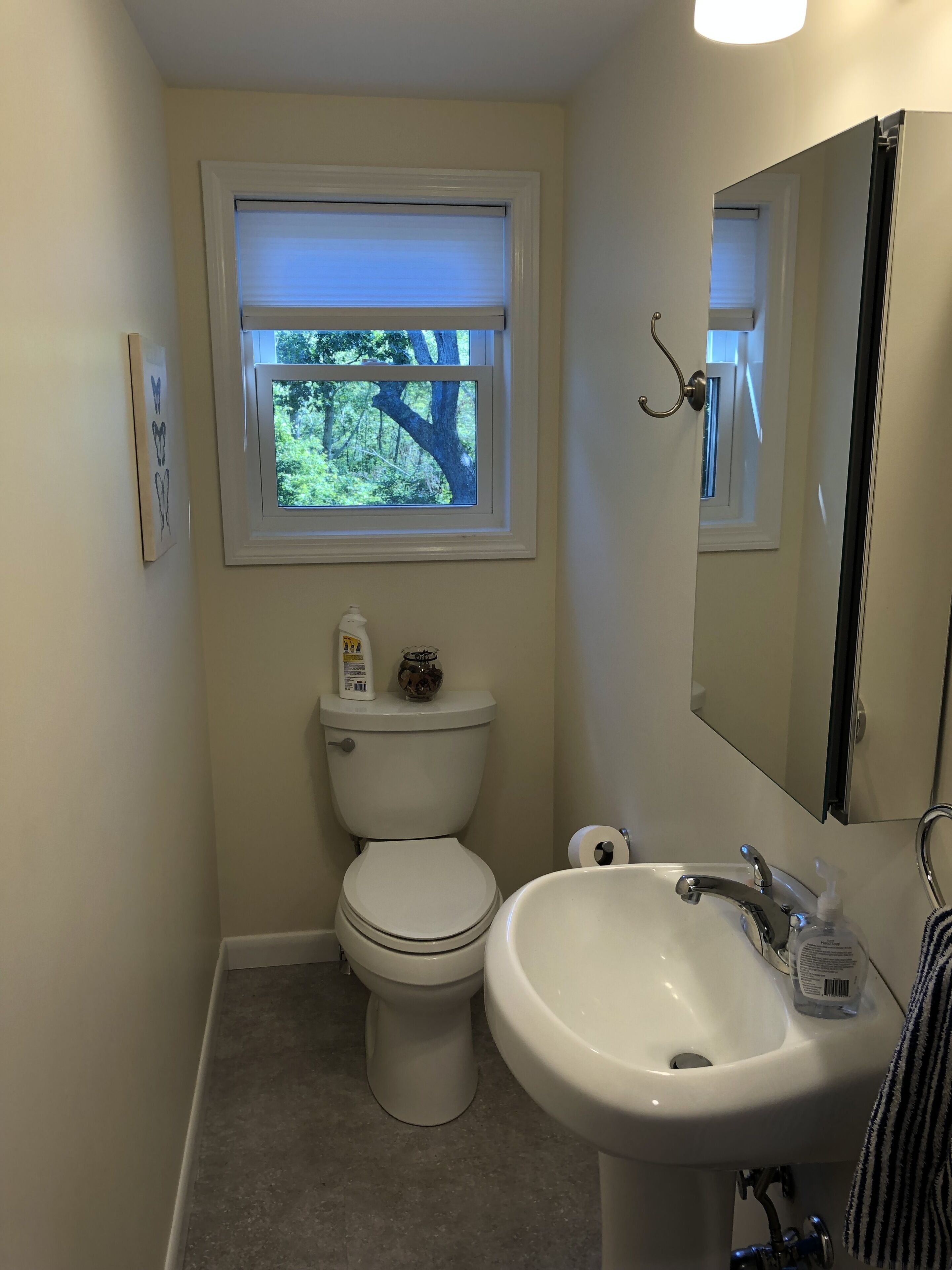 Un baño pequeño con inodoro, lavamanos y ventana.