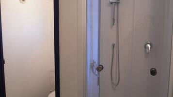 Een douche, handdoeken, toiletpapier