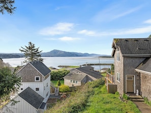 Área residencial com casas, vista ampla de um corpo d'água e montanha ao longe.