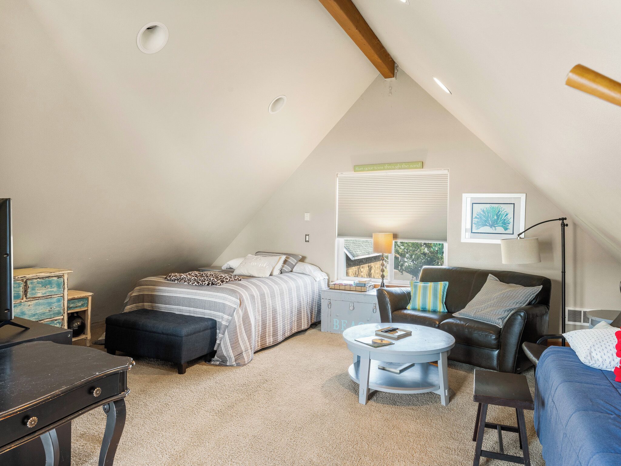 Une chambre confortable située dans les combles, avec un lit, un canapé, une table basse et un bureau.