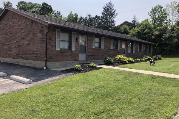 Brick triple with side paved parking lot.