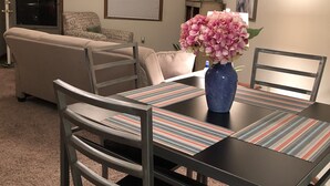 A dining area with a table, chairs, and a vase of flowers.