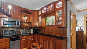 A kitchen with wooden cabinets, a microwave, a coffee maker, and a dishwasher.