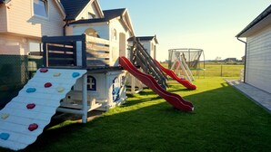 A playground with slides and climbing walls in a grassy yard. - Cottages for families with children or guests who want to relax. (Sarbinowo)