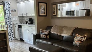 A modern kitchen with white cabinets, a microwave, and a coffee maker. - Apple Valley 23 at Rumbling Bald (Lake Lure)