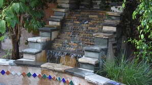 A stone staircase leading to a small waterfall, surrounded by greenery. - A Luxury Home with Pool, Spa, and Mini-golf (Los Angeles)